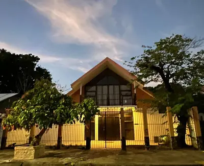 a yellow house with a fence in front of it at Villa de Playa, Paseo de los Turistas in Puntarenas