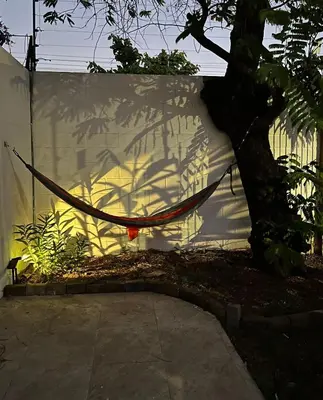 a hammock in front of a white fence at Villa de Playa, Paseo de los Turistas in Puntarenas