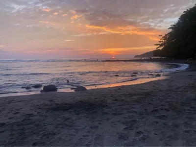 a sunset on a beach with the ocean at Sarahs Villas in Parrita