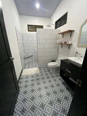 a bathroom with a toilet and a sink at Sarahs Villas in Parrita
