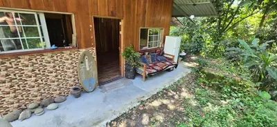 a bench sitting on the porch of a house at Cabaña Rio Diamante in Barú