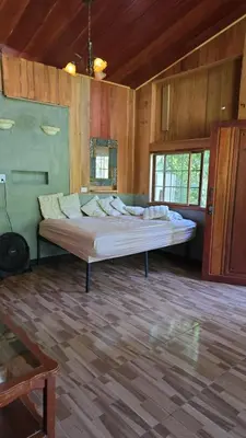 a large bed in a room with wooden walls at Cabaña Rio Diamante in Barú