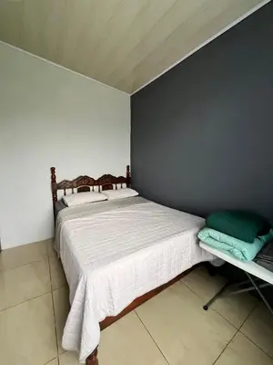 a bedroom with a bed and a gray wall at Bellavista Ceci A2 in San Ramón