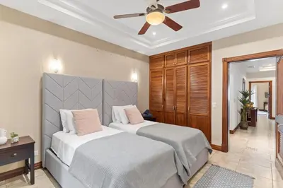 a bedroom with two beds and a ceiling fan at HM103 Blissful 2BR Beachfront Condo in Tamarindo