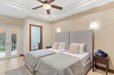 a bedroom with two beds and a ceiling fan at HM103 Blissful 2BR Beachfront Condo in Tamarindo
