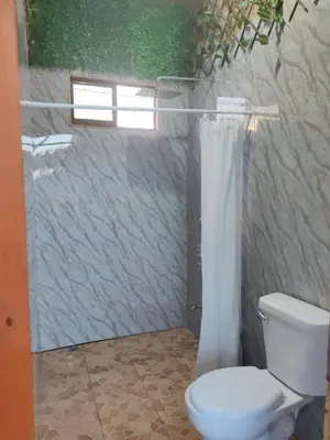 a bathroom with a toilet and a shower curtain at Villa Manzú Santa Cruz, Guanacaste in Santa Cruz