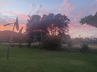a sunset over a park with a flag and trees at Villa Manzú Santa Cruz, Guanacaste in Santa Cruz