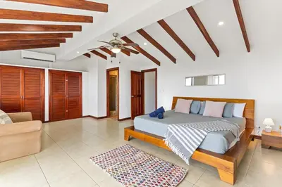 a bedroom with a bed and a living room at MPH Spacious Penthouse with Ocean Views in Tamarindo