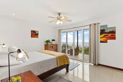 a bedroom with a bed and a large window at MPH Spacious Penthouse with Ocean Views in Tamarindo