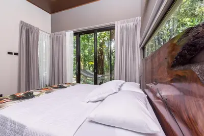 a bedroom with a bed and a large window at Río Sarapiquí Lodge in Sarapiquí