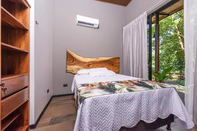 a bedroom with a bed and a large window at Río Sarapiquí Lodge in Sarapiquí