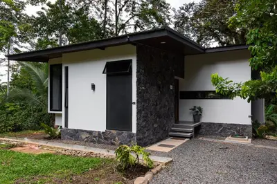 a small house with a black roof at Río Sarapiquí Lodge in Sarapiquí