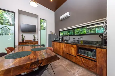 a dining room with a wooden table and a counter at Río Sarapiquí Lodge in Sarapiquí