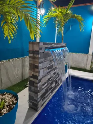 a water fountain in a pool with a palm tree at Alma y Paz Beach House in Bejuco