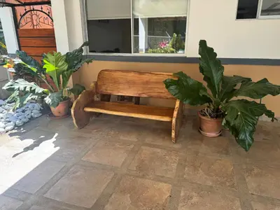 a wooden bench sitting in a room with plants at Alma y Paz Beach House in Bejuco