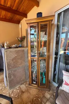 a wooden cabinet with glass doors in a room at Alma y Paz Beach House in Bejuco