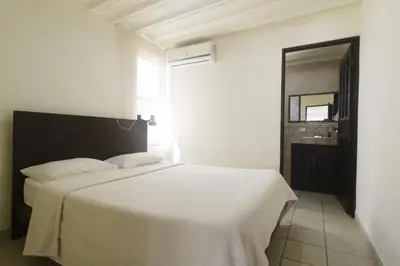 a bedroom with a white bed and a mirror at JS -14B home in Jacó