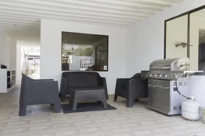 a kitchen with chairs and a grill in a room at JS -14B home in Jacó