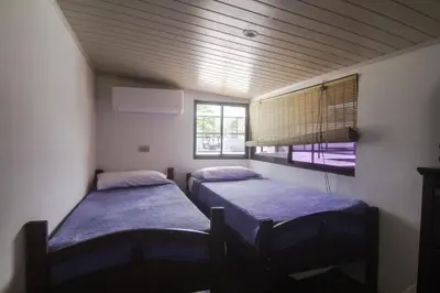 two beds in a small room with a window at JS -14B home in Jacó