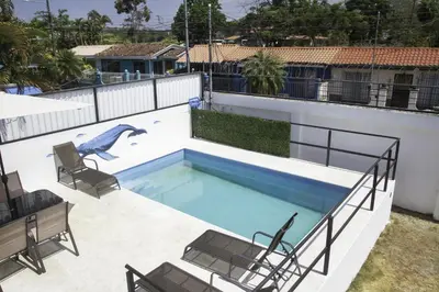 a swimming pool with two chairs and a swimming pool at JS -14B home in Jacó