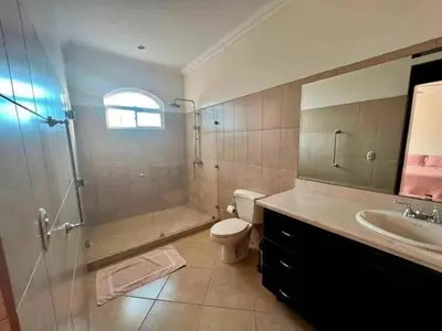 a bathroom with a shower and a toilet and a sink at Pacific Sun Penthouse in Herradura