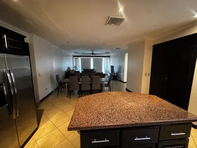 a kitchen and dining room with a table and a refrigerator at Pacific Sun Penthouse in Herradura