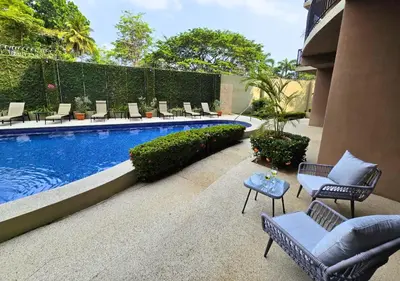 a patio with chairs and a swimming pool at Monaco Condominiums Unit 3, Poolside 3BR, Walk to Beach in Jacó