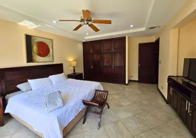 a bedroom with a bed and a ceiling fan at Monaco Condominiums Unit 3, Poolside 3BR, Walk to Beach in Jacó
