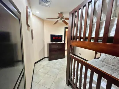 a bedroom with a bunk bed and a tv at Monaco Condominiums Unit 3, Poolside 3BR, Walk to Beach in Jacó