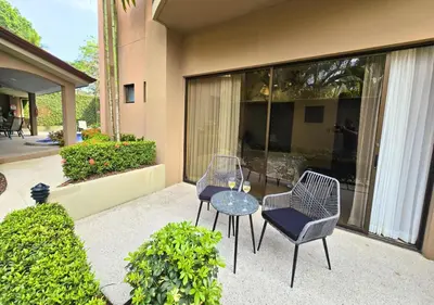 a patio with two chairs and a glass table at Monaco Condominiums Unit 3, Poolside 3BR, Walk to Beach in Jacó