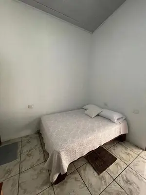 a small bedroom with a bed in the corner at Casa Los Delfines in Tortuguero