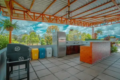 an outdoor kitchen with a grill and trash cans at Casa vacacional cerca de la Fortuna San Carlos in Tanque