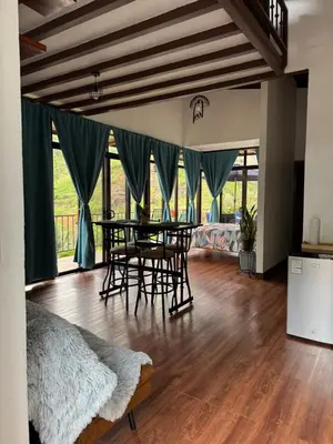 a bedroom with a table and chairs in a room at Cabaña Lotf Atenas in San Isidro