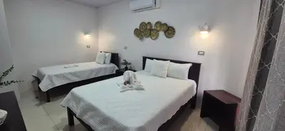 a hotel room with two beds with white sheets at House in the heart of La Fortuna in Fortuna