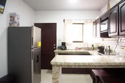 a kitchen with a refrigerator and a counter top at House in the heart of La Fortuna in Fortuna