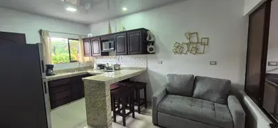 a kitchen with a bar and a couch in a room at House in the heart of La Fortuna in Fortuna