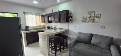 a kitchen with a bar and a couch in a room at House in the heart of La Fortuna in Fortuna