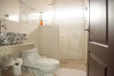 a white bathroom with a toilet and a shower at House in the heart of La Fortuna in Fortuna