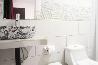 a white bathroom with a sink and a toilet at House in the heart of La Fortuna in Fortuna