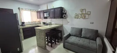 a kitchen with a couch and a kitchen with a counter at House in the heart of La Fortuna in Fortuna