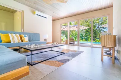a living room with a blue couch and a table at Chalet Tropical - by Pura Villas in Ballena
