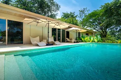 a swimming pool in front of a house at Chalet Tropical - by Pura Villas in Ballena