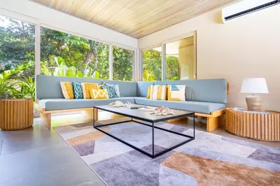 a living room with a blue couch and a table at Chalet Tropical - by Pura Villas in Ballena