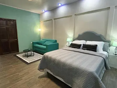 a bedroom with a bed and a green couch at La Cueva del Perezoso in Ángeles