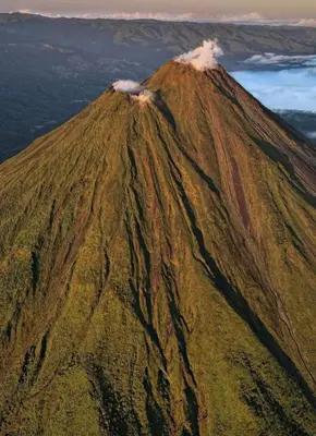an erupting volcano on top of a mountain at La Cueva del Perezoso in Ángeles