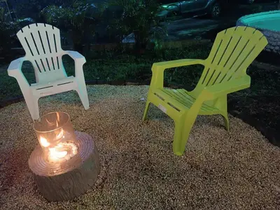 two lawn chairs and a candle in a yard at La Cueva del Perezoso in Ángeles