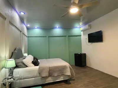 a bedroom with a bed and a ceiling fan at La Cueva del Perezoso in Ángeles