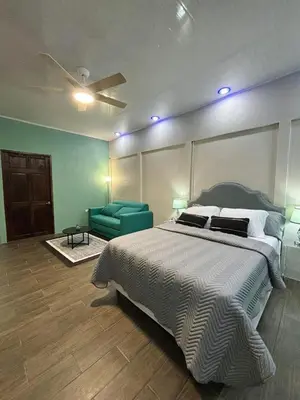 a bedroom with a large bed and a green couch at La Cueva del Perezoso in Ángeles