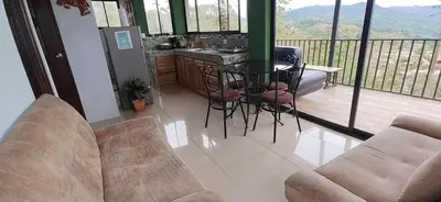 a living room with a balcony with a table and chairs at Bella vista Ceci B1 in San Ramón