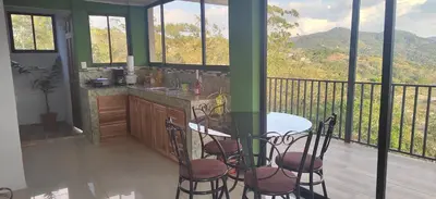 a kitchen with a table and chairs on a balcony at Bella vista Ceci B1 in San Ramón